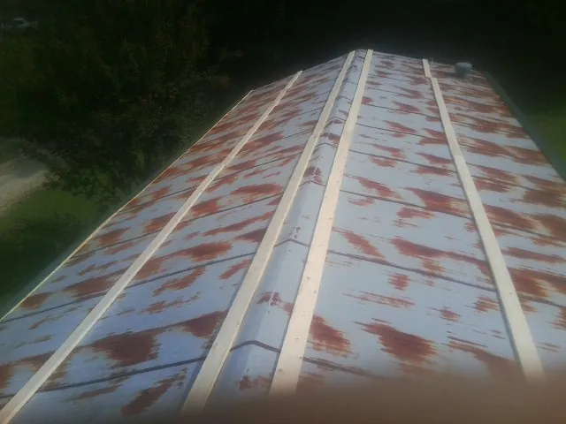 Rusted metal roof panels with new wood purlins before replacement — Storm Damage Roof Repair in Nolanville by Roofing Brothers