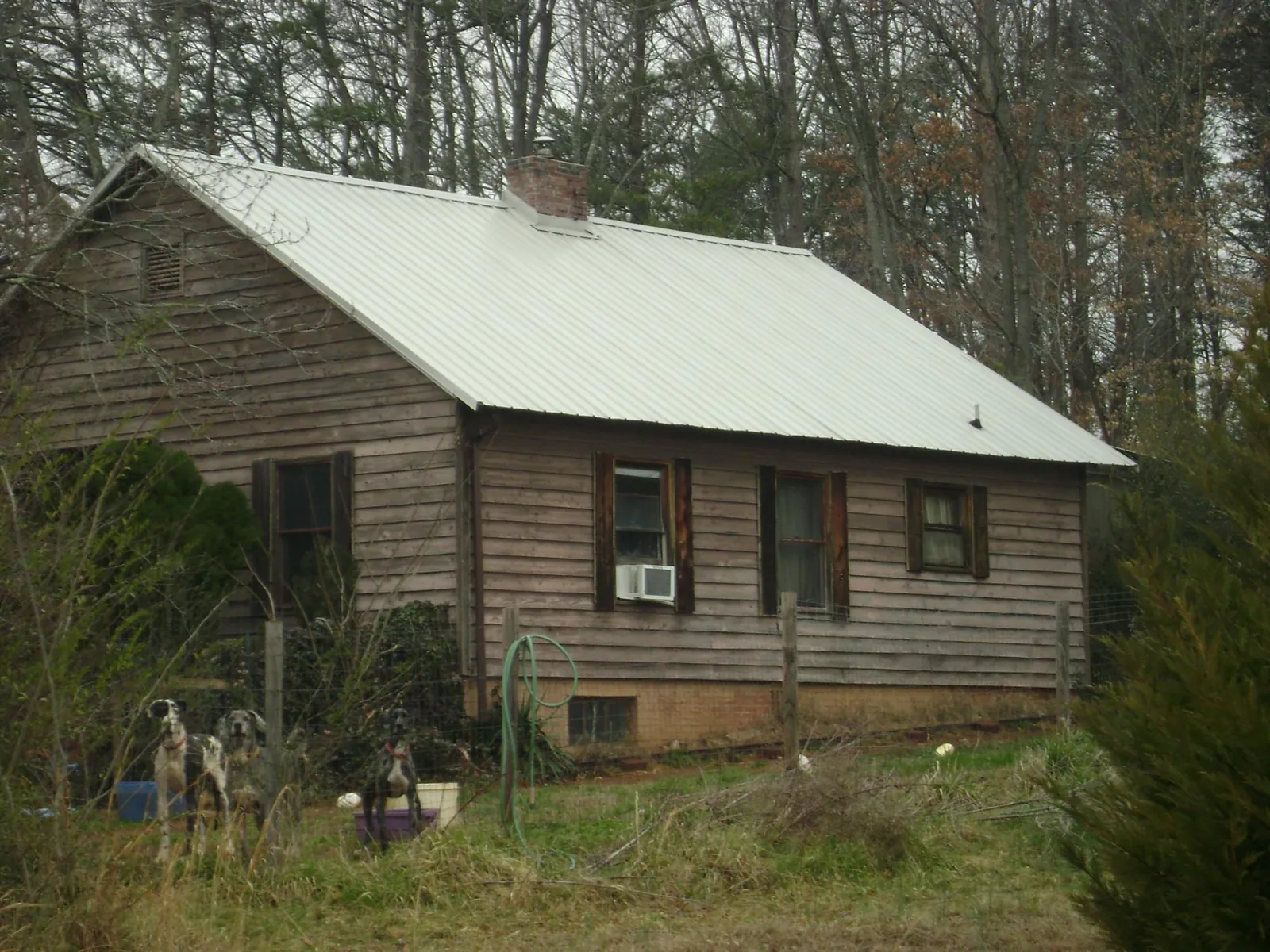 White metal roof on an old wood sided farmhouse, from a Metal Roof Installation job in Nolanville